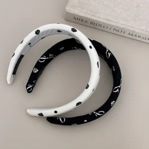 Detail of simple printed headbands with floral and bow patterns in black and white.