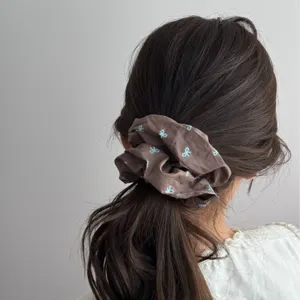 Retro brown cloth scrunchie with blue bow pattern for elegant ponytail hair styling
