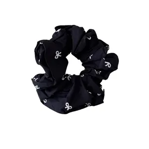 Black oversized scrunchie hair tie with white bow patterns for ponytails and buns