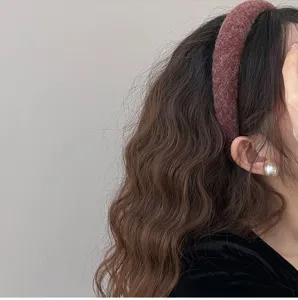 Close-up view of a thick plush felt hair headband in reddish-brown on a model's head