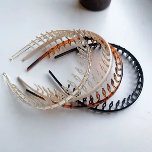Set of minimalist hairbands with long teeth in multiple colors on a white surface