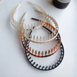 Detailed view of 4-color long-tooth hairbands in tortoiseshell, black, and cream plastic