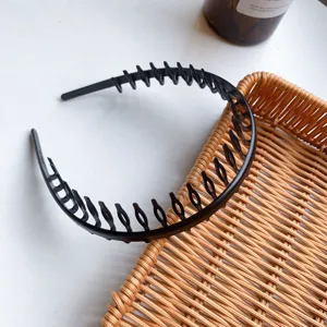 Macro detail showing the durable long teeth of a black non-slip plastic hair hoop.