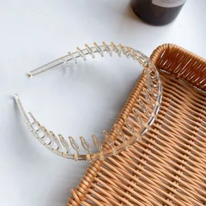 Detailed view of transparent toothed headband for hair styling on rattan tray