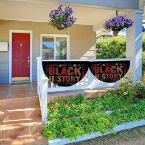 Black History Month decorative fan flags hanging on a wooden porch railing