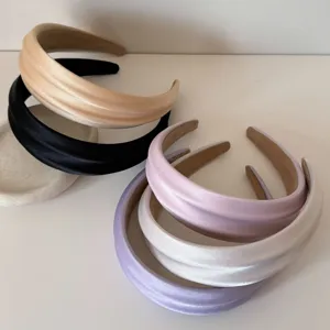 Group of padded satin headbands in assorted pastel colors for hair styling.