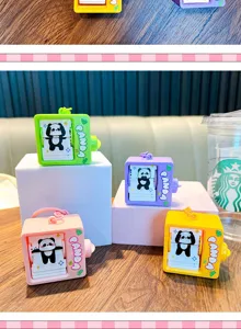 Detailed view of panda flip animation keychains in four vibrant colors on a wooden table.