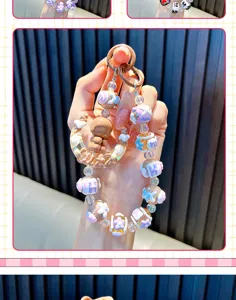 Close-up of handmade beaded phone strap with a moon girl charm and colorful letter beads
