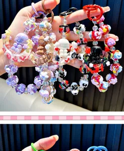 Detailed shot of handmade beaded phone charms with moon and girl character pendants.