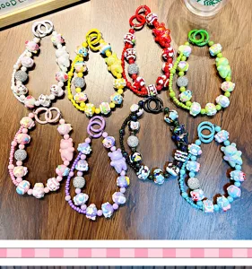 Detailed view of colorful beaded bear keychains and phone charms on wooden surface