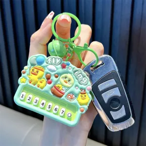 Cartoon mint green piano keychain with cute yellow duck characters and bell charm