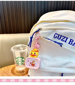 Nahaufnahme eines niedlichen gelben Enten-Schlüsselanhängers an einem weißen Rucksack
