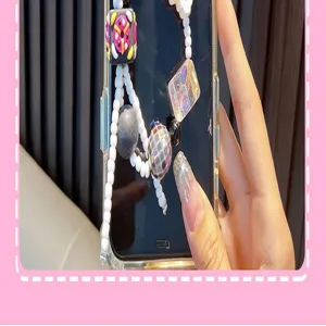 Close-up detail of colorful hand-painted block and pearl beaded phone strap