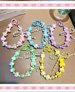 Detailed view of colorful beaded bear phone straps and keychains in five pastel colors.