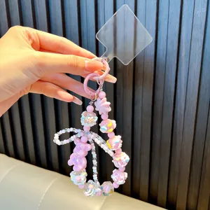 Handcrafted cute pink beaded phone charm featuring a resin bear and butterfly knot accessory