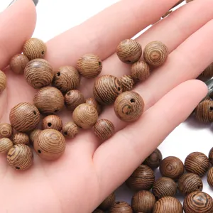 Dettaglio macro di perline in legno di wengé naturale con venature uniche per gioielli fai da te.