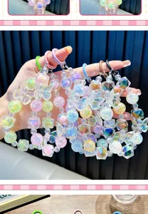 Hand holding a set of colorful iridescent butterfly beaded phone straps in detail