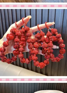 Detailopname van rode kralen telefoonhangers met strikken en pluizige ballen