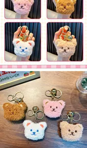 Detail view of plush bear head keychains in four colors with gold metal rings.