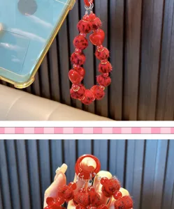 Detailweergave van een rode kralen telefoonketting met hartjes en luipaard pluche ballen