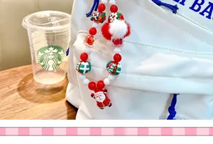 Detail of a Christmas beaded bag charm featuring a Santa Claus pendant and soft pom-pom.