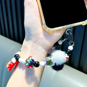 Handmade Christmas beaded phone strap featuring festive charms and soft furry pom-poms