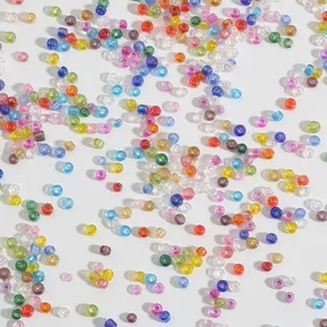 Dettaglio macro di perline di vetro colorate e iridescenti per gioielli fai da te.
