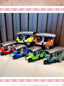 Detailed view of colorful miniature pull-back rickshaw tuk-tuk toy model keychains