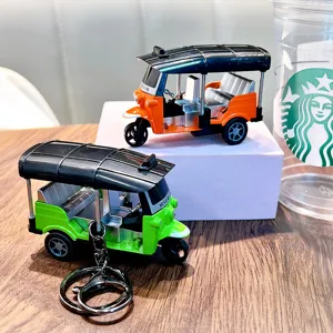 Detailed miniature pull-back toy tuk-tuk rickshaw model keychain in orange and green