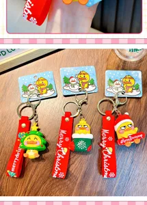 Set of three festive Christmas yellow duck keychains displayed on a rustic wooden table