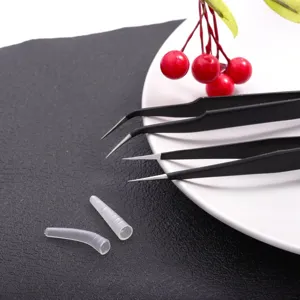 Close-up view of stainless steel straight and curved nail art tweezers with silicone caps