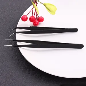 Detailed view of anti-static stainless steel straight and curved tweezers on a white plate