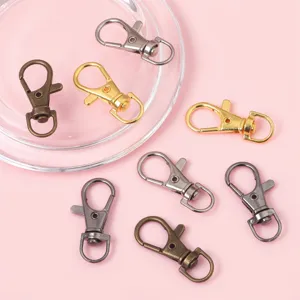 Set of alloy lobster clasps for DIY keychains in various metallic finishes on pink background