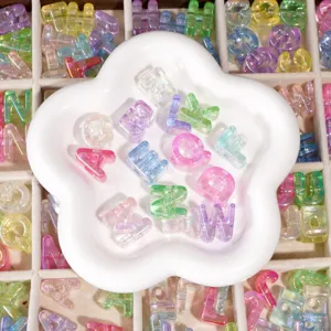 Macro view of translucent iridescent acrylic alphabet beads displayed in a white flower tray