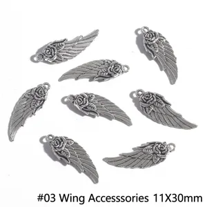 Detailed view of antique silver alloy wing charms with rose motifs for DIY jewelry crafting.