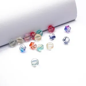Detailed view of colorful pumpkin-shaped lampwork glass beads for DIY jewelry making.