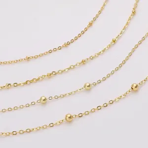 Macro view of 18K gold-plated necklace chains featuring small gold bead details