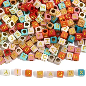 Detailed view of colorful square acrylic alphabet beads with golden letters for DIY