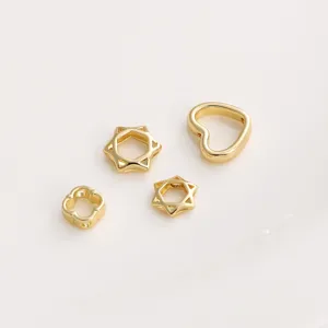 Close-up of golden hollow hexagram and heart-shaped spacer beads for DIY jewelry making