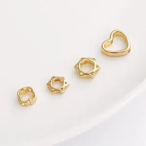 Close-up of golden hollow hexagram and heart-shaped spacer beads for DIY jewelry