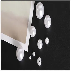 Detailed close-up showing various sized white ABS acrylic pearl beads for DIY jewelry