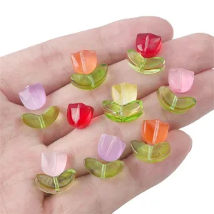 Nahaufnahme bunter tulpenförmiger Glasperlen für die Schmuckherstellung auf einer Hand
