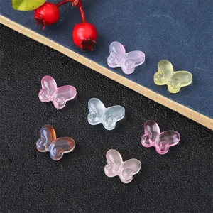 Detailed view of colorful transparent glass butterfly beads for DIY jewelry making.