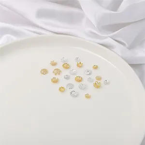 Nahaufnahme von goldenen und silbernen Schmuck-Blumenkappen und Perlen-Abstandhaltern