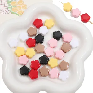 Vue macro de perles de fleurs en acrylique colorées pour bijoux DIY dans un plat