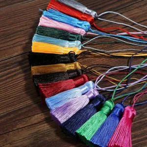 Detail showing a colorful assortment of silk-like DIY tassels on a wood background