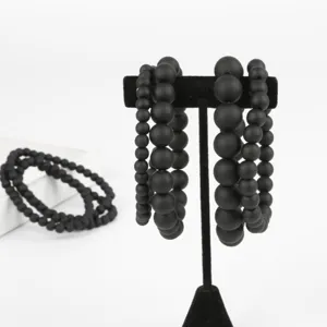 Detailansicht von mattschwarzen Perlenarmbändern in verschiedenen Größen auf einem Ständer
