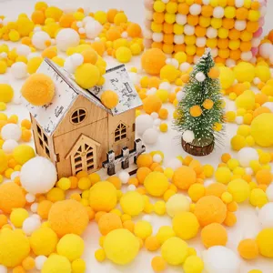 Pompones de peluche amarillos y naranjas de varios tamaños para manualidades DIY.