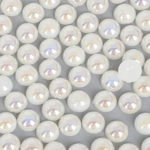 Vue macro de perles ABS semi-circulaires irisées blanc crème à fond plat.