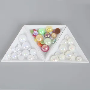 Demi-perles irisées de tailles variées présentées dans des plateaux triangulaires